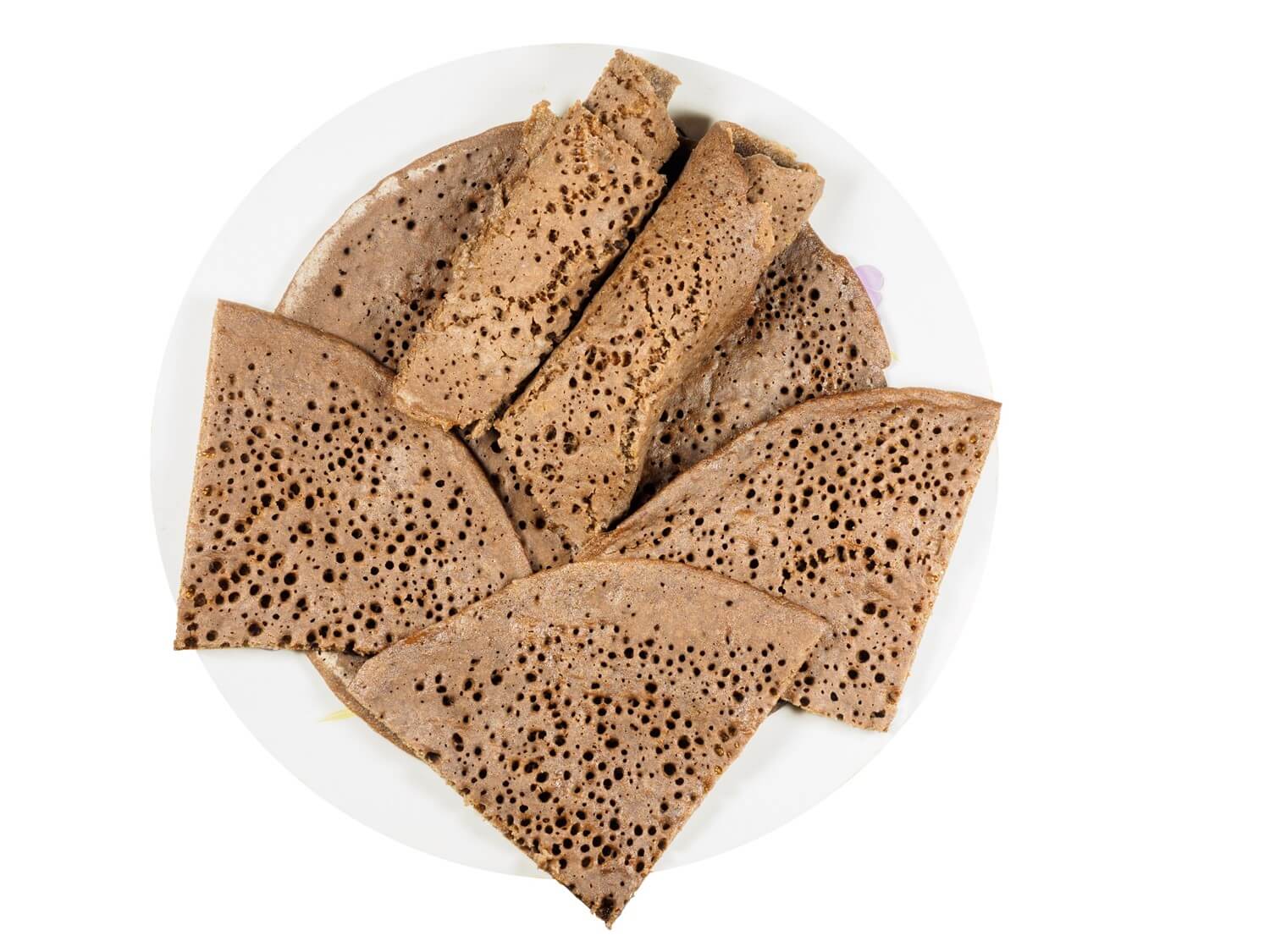 Brown thin flatbread/wrap with holes caused by air bubbles.. 